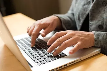 person typing on a laptop